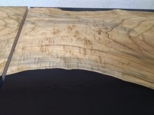 Live-edge hardwood slab with rich grain and natural edge, ideal for custom tables and wooden doors.