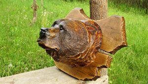 Hand-carved wooden fish sculpture outdoors, showcasing the craftsmanship behind our wooden tables and doors.