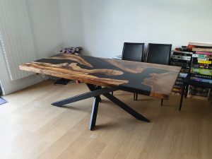 Handcrafted live-edge wooden dining table with black X-frame legs, from our custom tables and wooden doors collection.