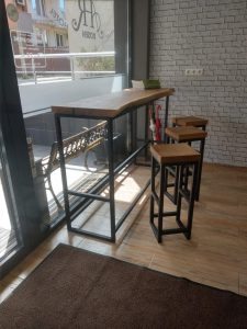 Showroom of a woodworking business featuring a handcrafted wooden high table and bar stools.
