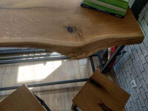 Live-edge wooden table top in a workshop, highlighting craftsmanship for custom tables and wooden doors.