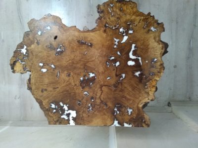 Live-edge wooden slab with rich grain and natural imperfections, ideal for custom tables and doors.