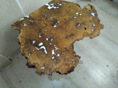 Live-edge wooden slab with natural edges and white epoxy resin fills, ideal for custom tables and doors.