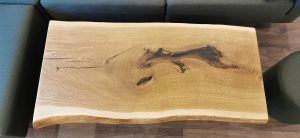 Live-edge wooden slab with natural grain and a knot, perfect for custom tables and doors.