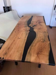 Handcrafted live-edge wooden table with a black epoxy river running through the center.