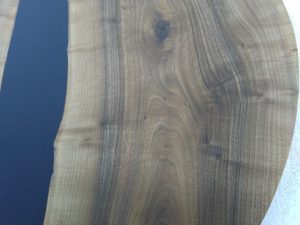 Round wooden tabletop with rich grain patterns and a smooth finish, ideal for handcrafted tables and doors.
