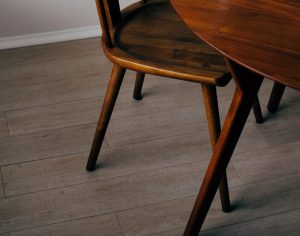 Round wooden dining table with matching chairs in a warm finish, highlighting handcrafted solid wood furniture.