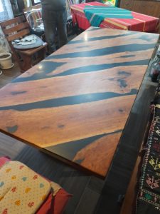 Handcrafted solid-wood dining table top with contrasting light and dark planks, ideal for custom tables and doors.