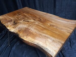 Handcrafted live-edge wooden table slab with rich grain and natural edge, perfect for tables and doors.