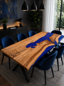Handcrafted live-edge wooden dining table with a blue epoxy resin river, set in a modern dining room with navy chairs.