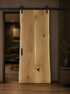 Handcrafted solid wood sliding barn door with black metal hardware in a modern interior, perfect for custom wooden doors and tables.