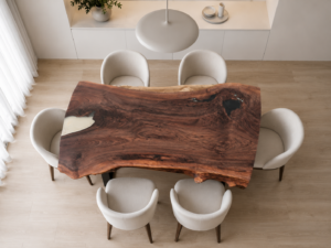 Handcrafted live-edge wooden dining table with rich grain and knots, surrounded by cream chairs in a bright showroom, showcasing our wooden tables and doors.