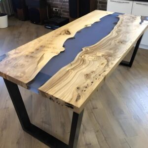 Handcrafted live-edge wooden dining table with a blue epoxy resin river, ideal for a furniture business offering custom tables and doors.