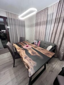 Handcrafted live-edge wooden dining table with a dark resin inlay in a modern dining room, ideal for custom tables and wooden doors.