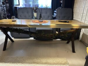 Handcrafted wooden dining table on display in a showroom, highlighting custom wooden tables and doors offered by the business.