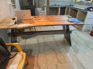 Handcrafted wooden table in a workshop, showcasing our custom wooden tables and doors.