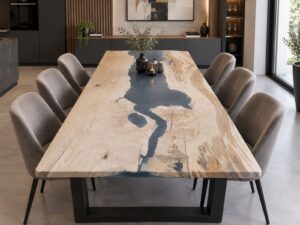 Long live-edge wooden dining table with a dark epoxy river running through it, surrounded by upholstered chairs in a modern showroom, showcasing our custom wooden tables and doors.